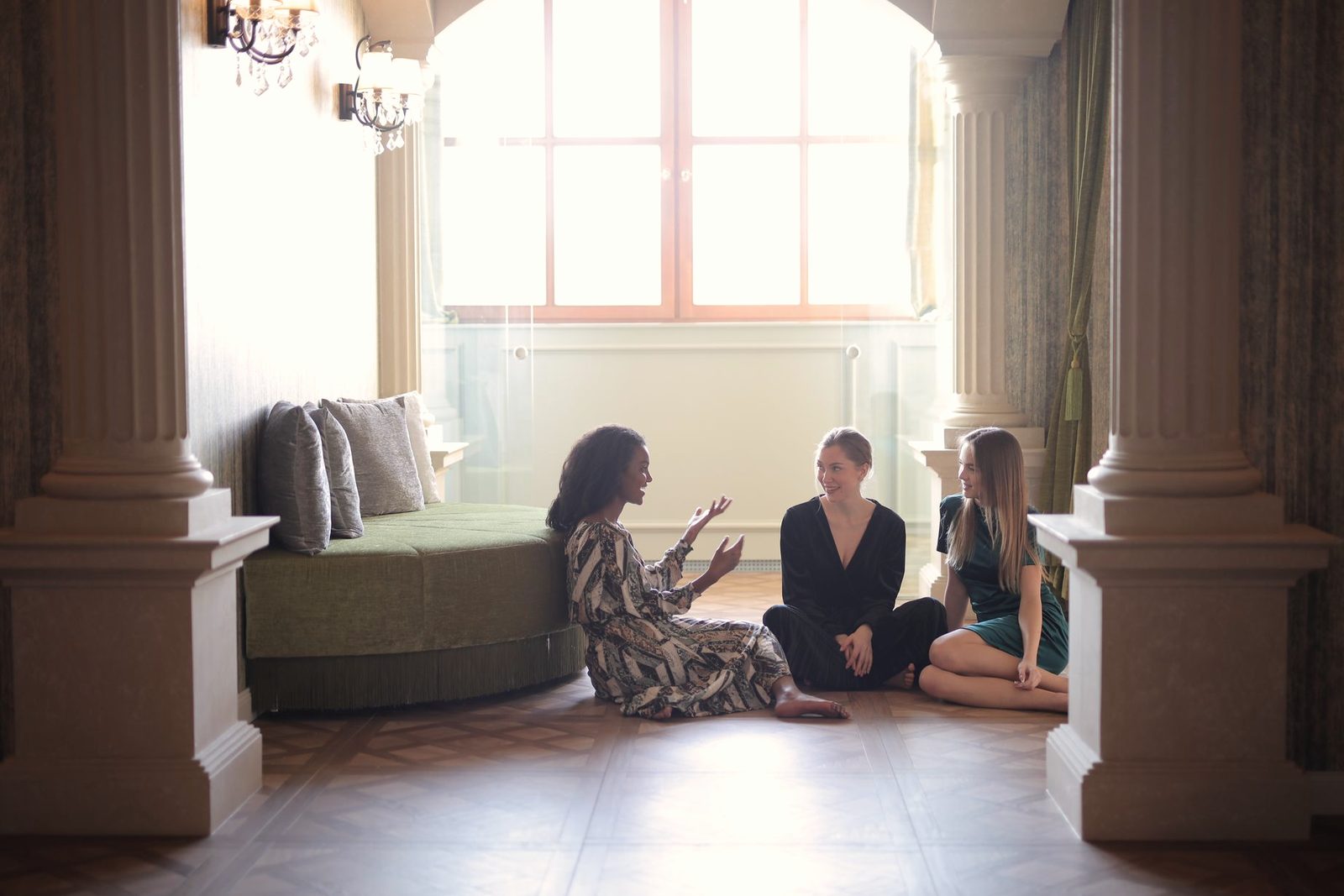 Three women sitting together talking in a bright, calm room